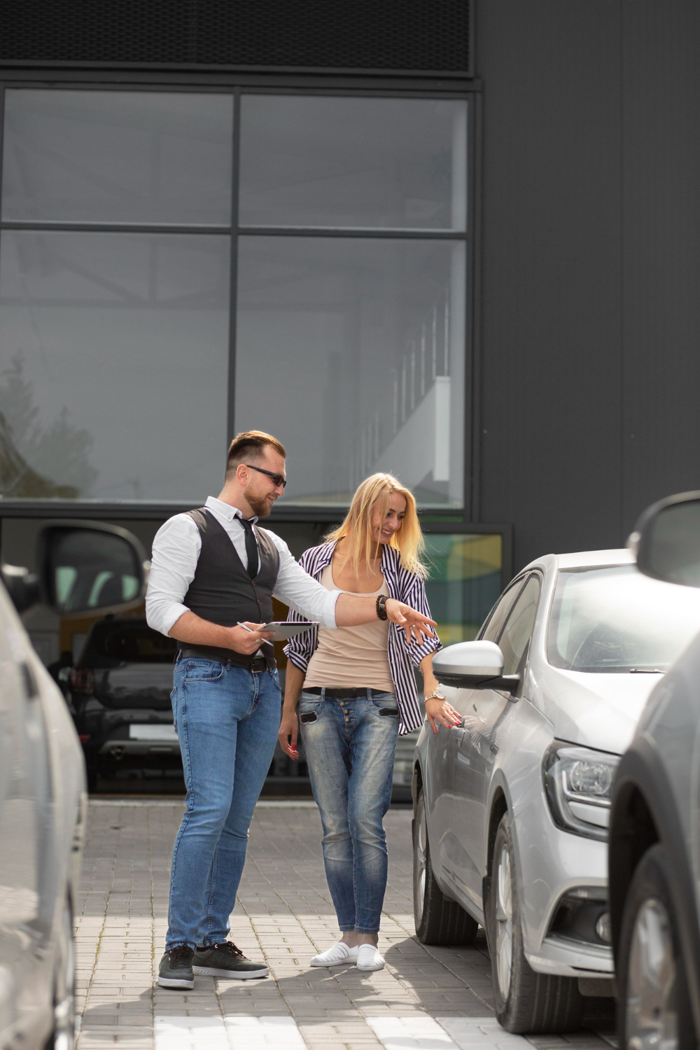 salesman showing a car to a customer